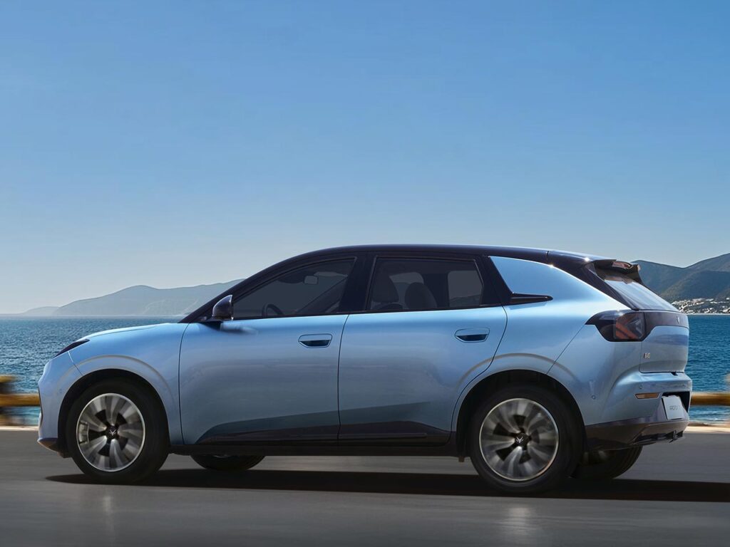 Side view of a Vana Blue all-electric ARCFOX T1 SUV driving by a harbour