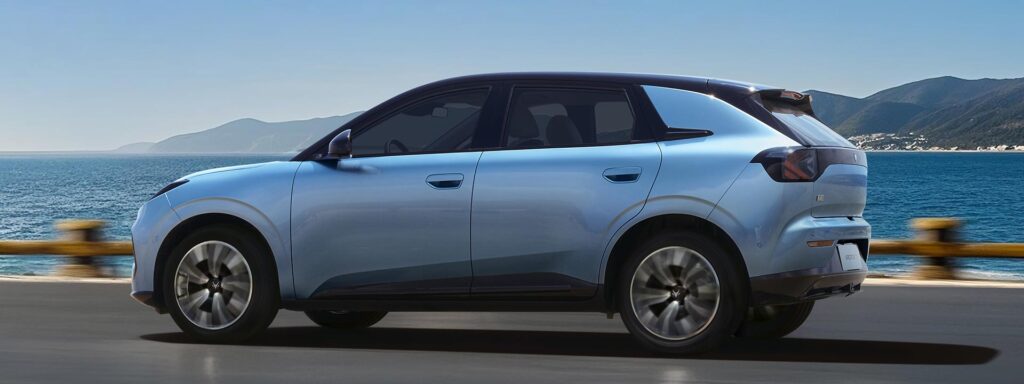 Side view of a Vana Blue all-electric ARCFOX T1 SUV driving by a harbour
