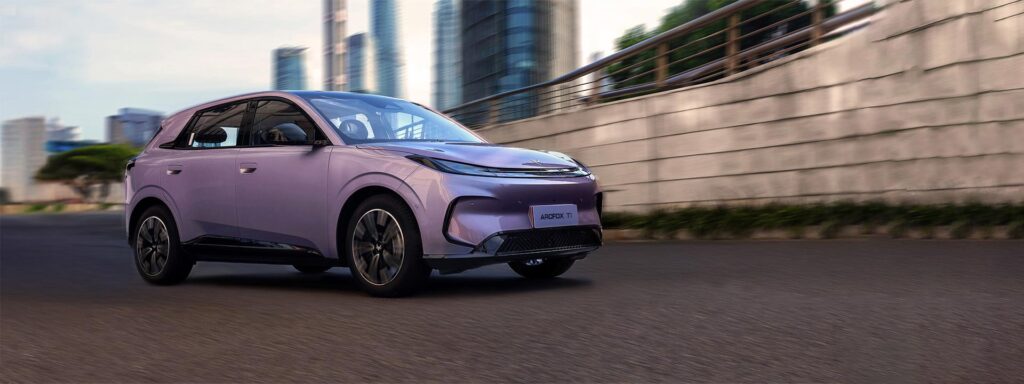 Front three quarter view of a purple ARCFOX T1 electric SUV driving on a city street