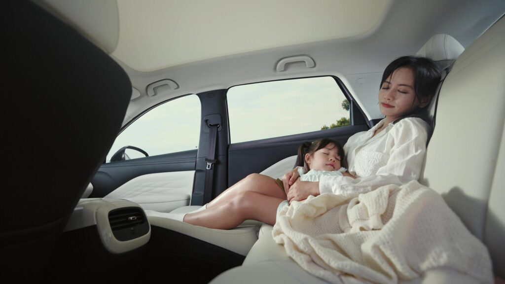 Woman holding her baby in the electrically adjustable front seat of the ARCFOX T1 electric SUV