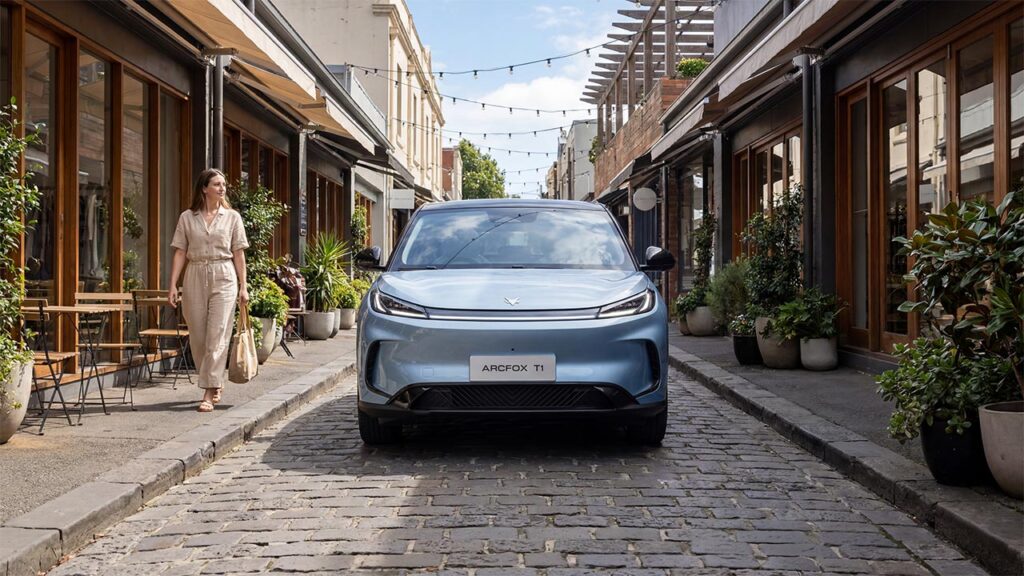 Front view of a blue ARCFOX T1 electric SUV driving down a cobblestone shopping street