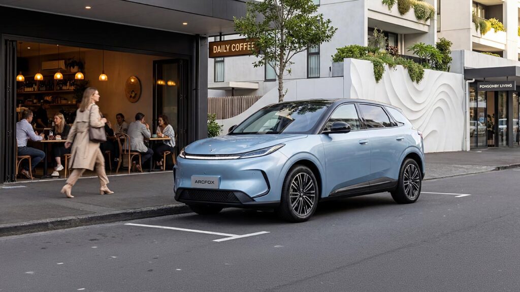 Front three quarter view of a blue ARCFOX T1 electric SUV parked in front of a coffee shop in Auckland